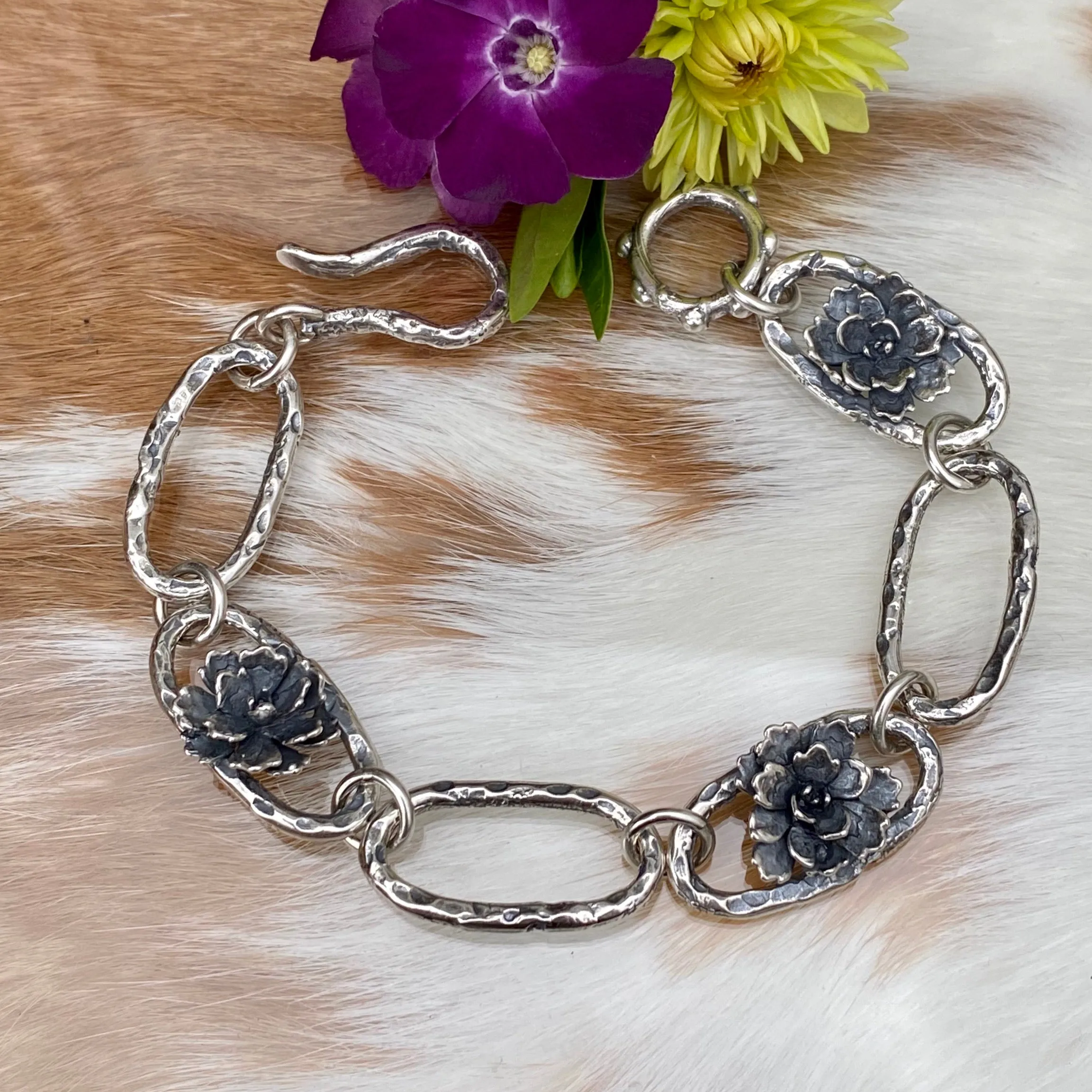 Hammered ovals with Succulent blooms. Hand cast sterling silver bracelet